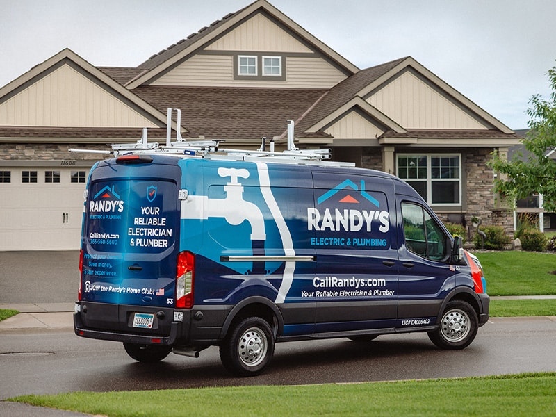 Randy's Electric & Plumbing van parked in front of a suburban house.