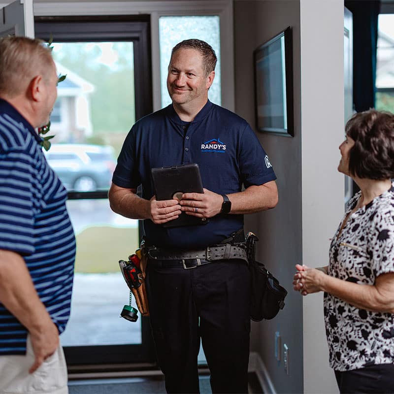 Randy's technician meeting with clients at home, holding a tablet.
